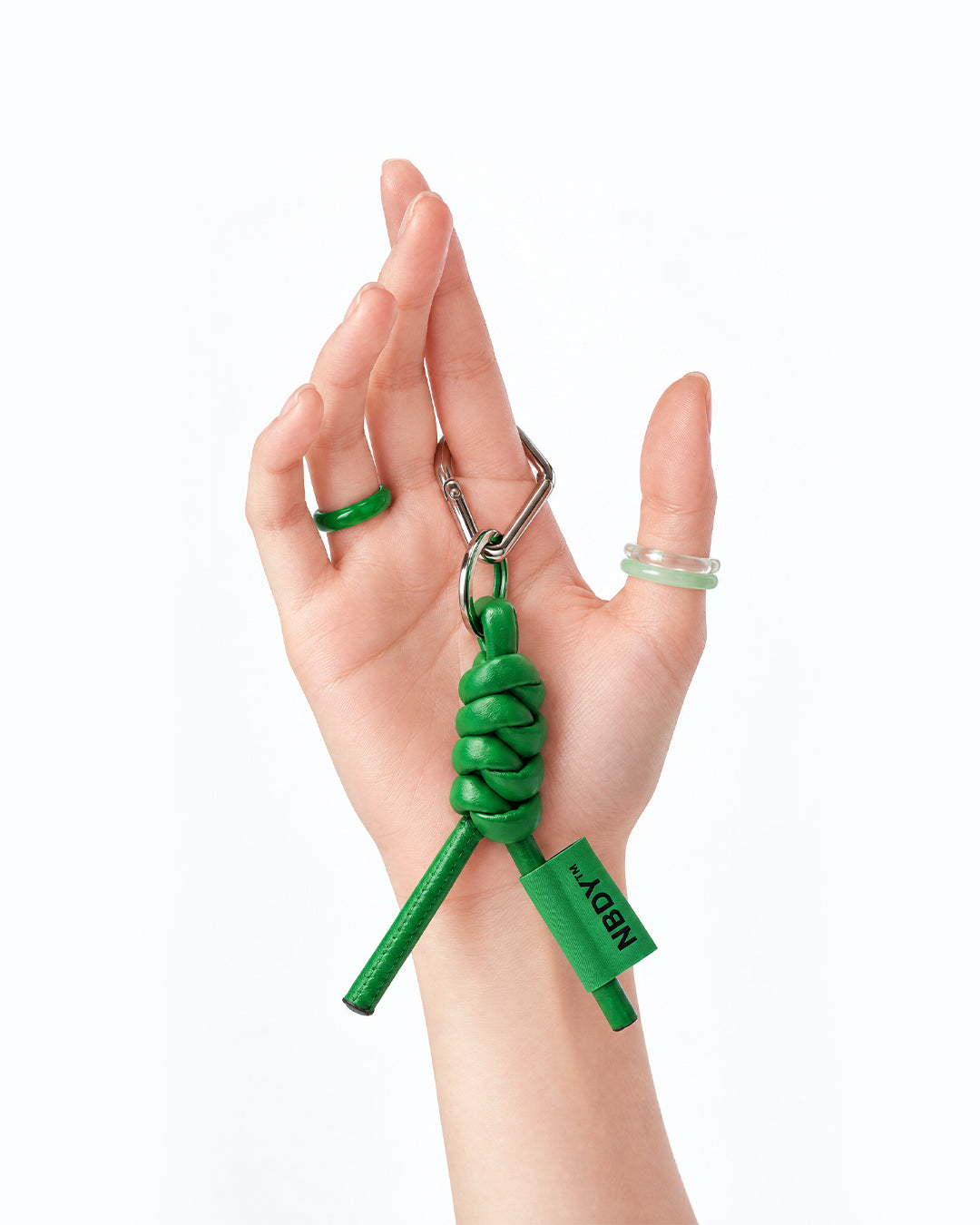 Hand holding the green NBDY keychain by its loop