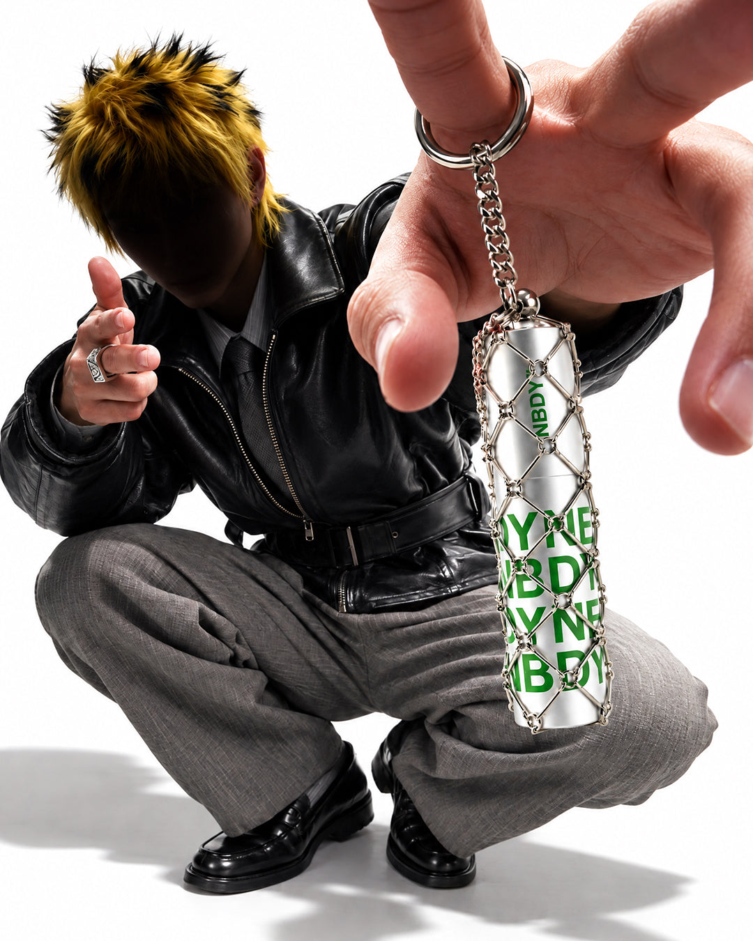 Crouching model holding the NBDY refillable atomiser out on its chain