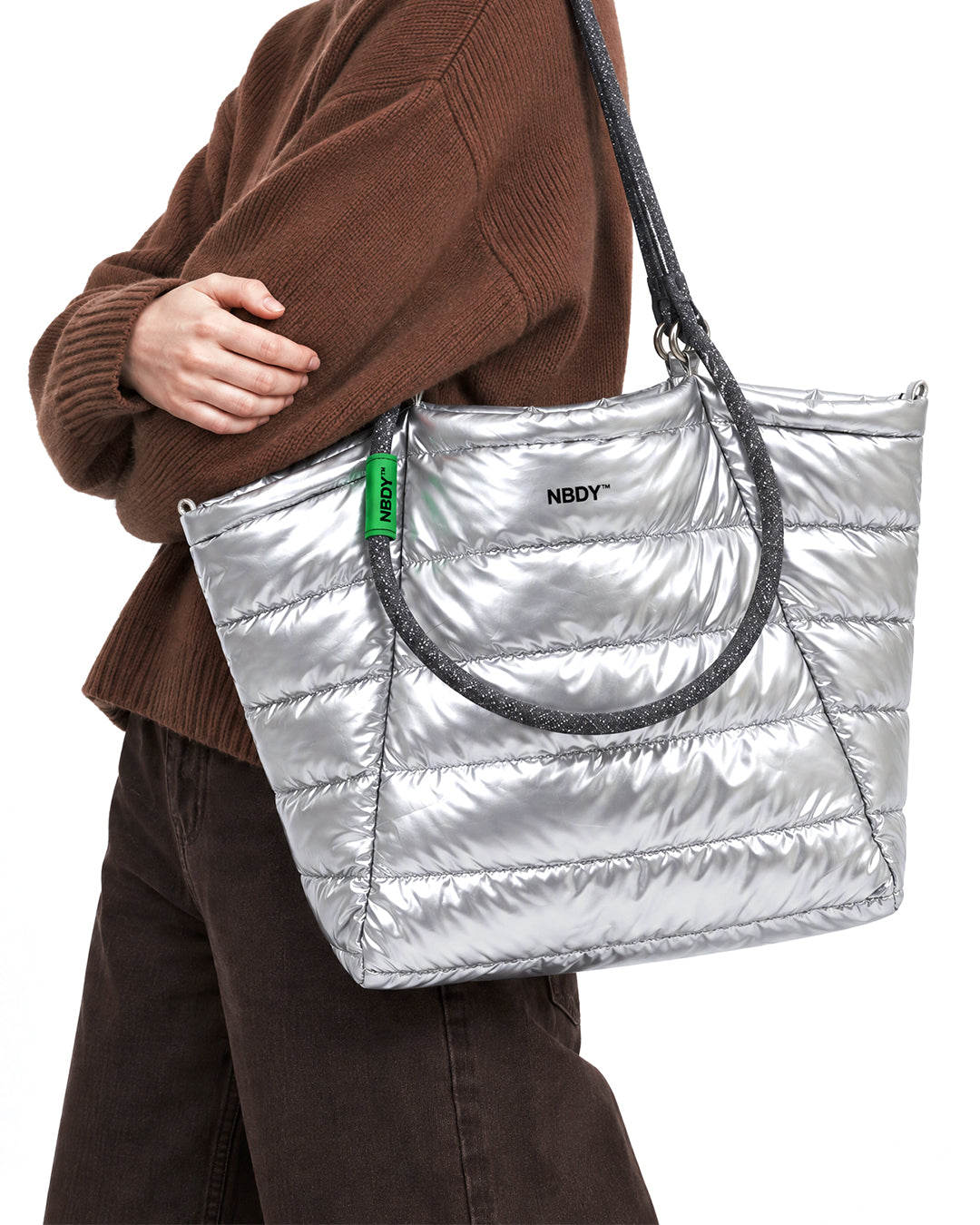 Model carrying the silver quilted NBDY tote bag on her shoulder